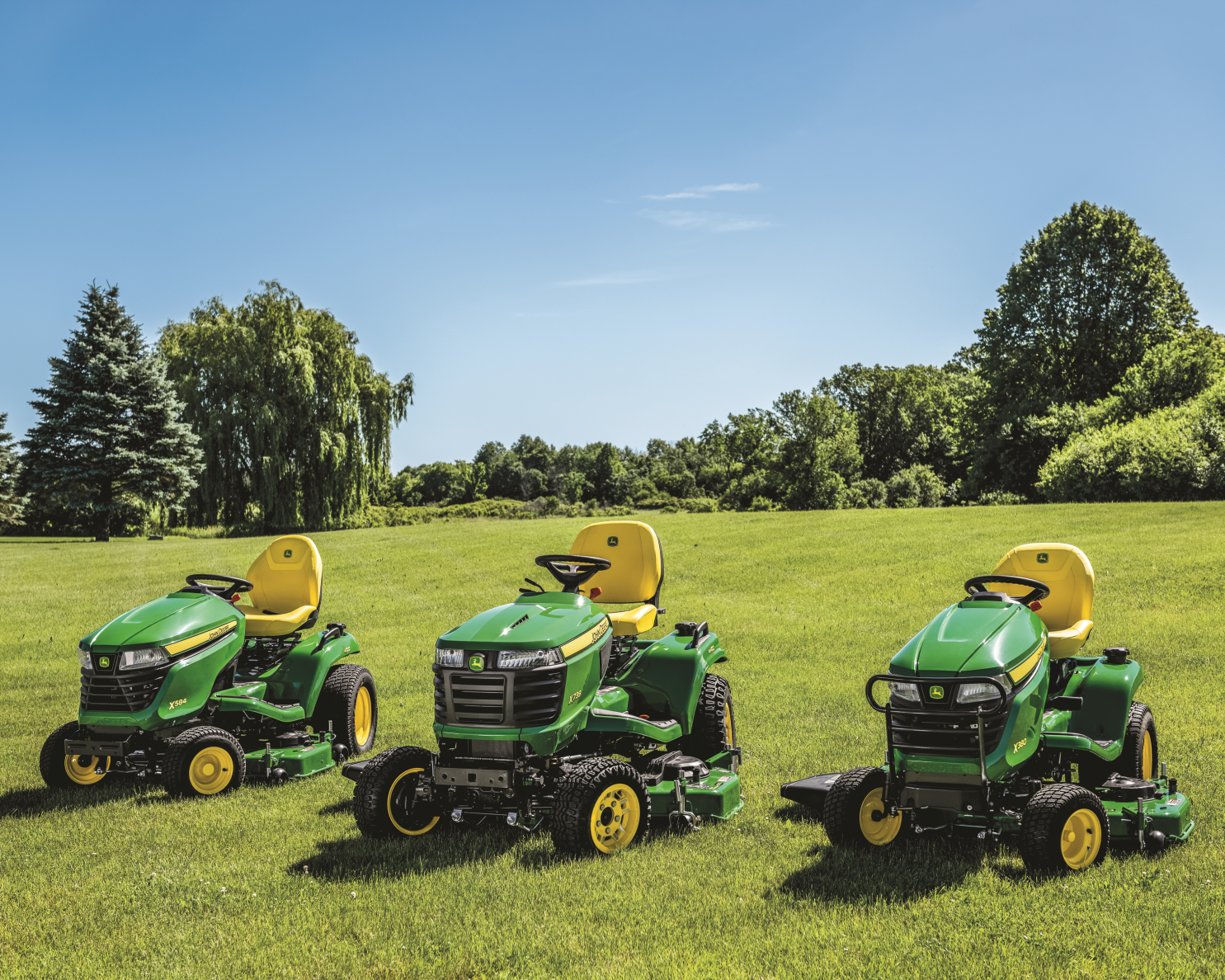 X380, X584, X739 Tractors are displaying on a green lawn