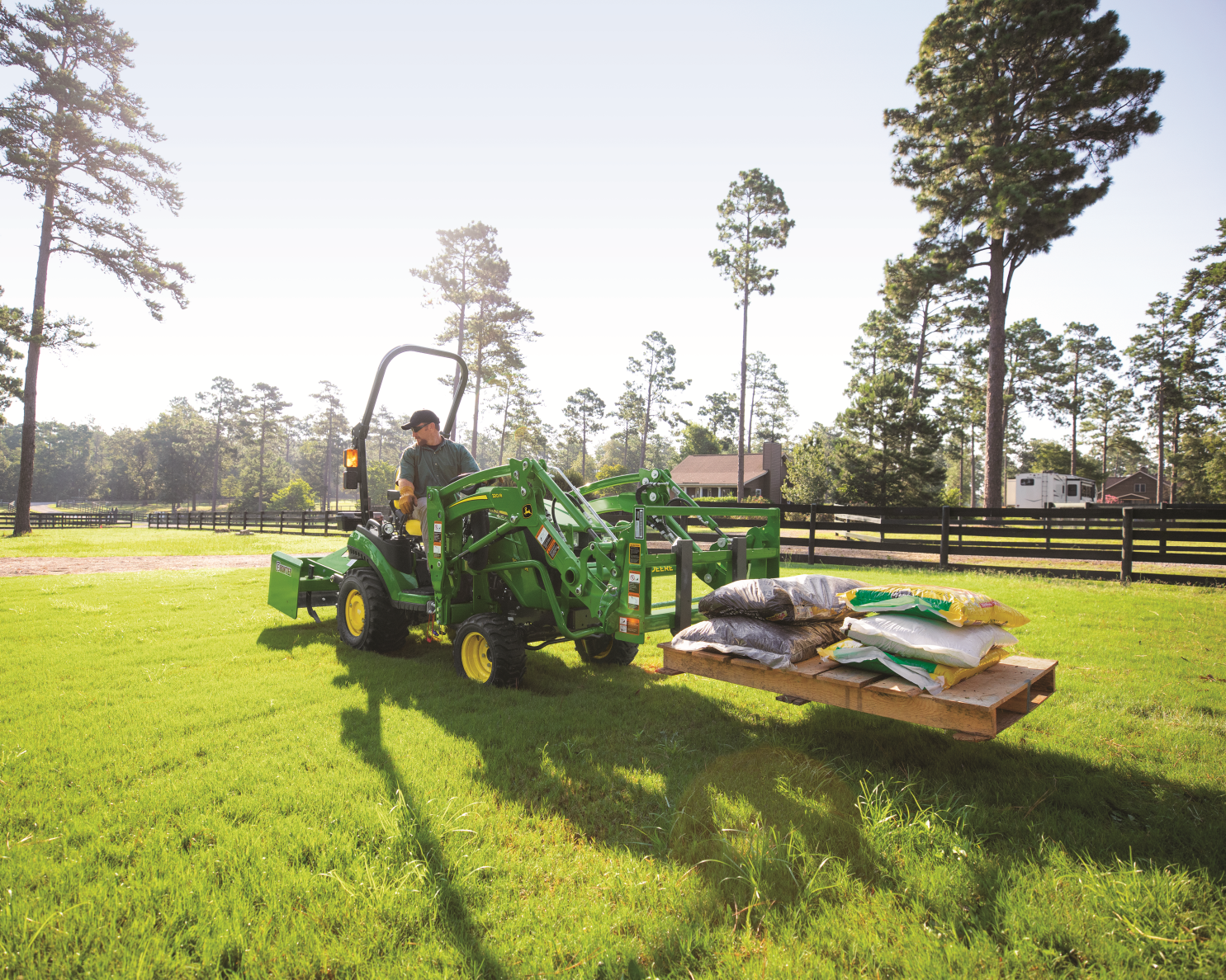 A worker is operating a John Deere Pallet Fork