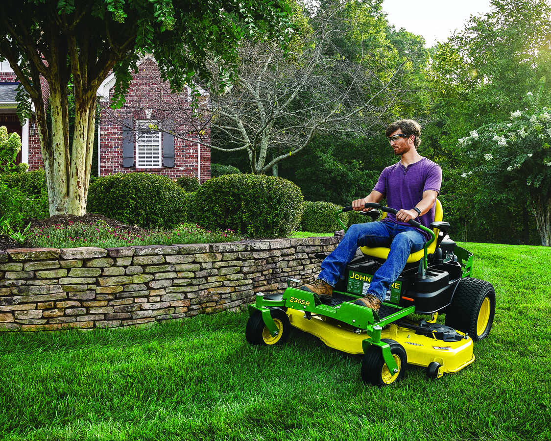 A man is driving on a John Deere Z365R ZTrakT Riding Mower